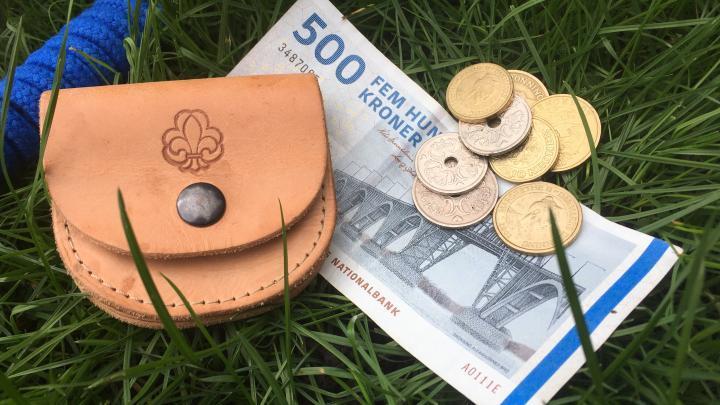 Foto af spejderpung, småpenge og en 500 krone seddel