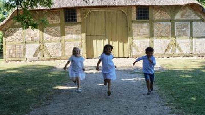 3 børn i løb ved en gammel gård